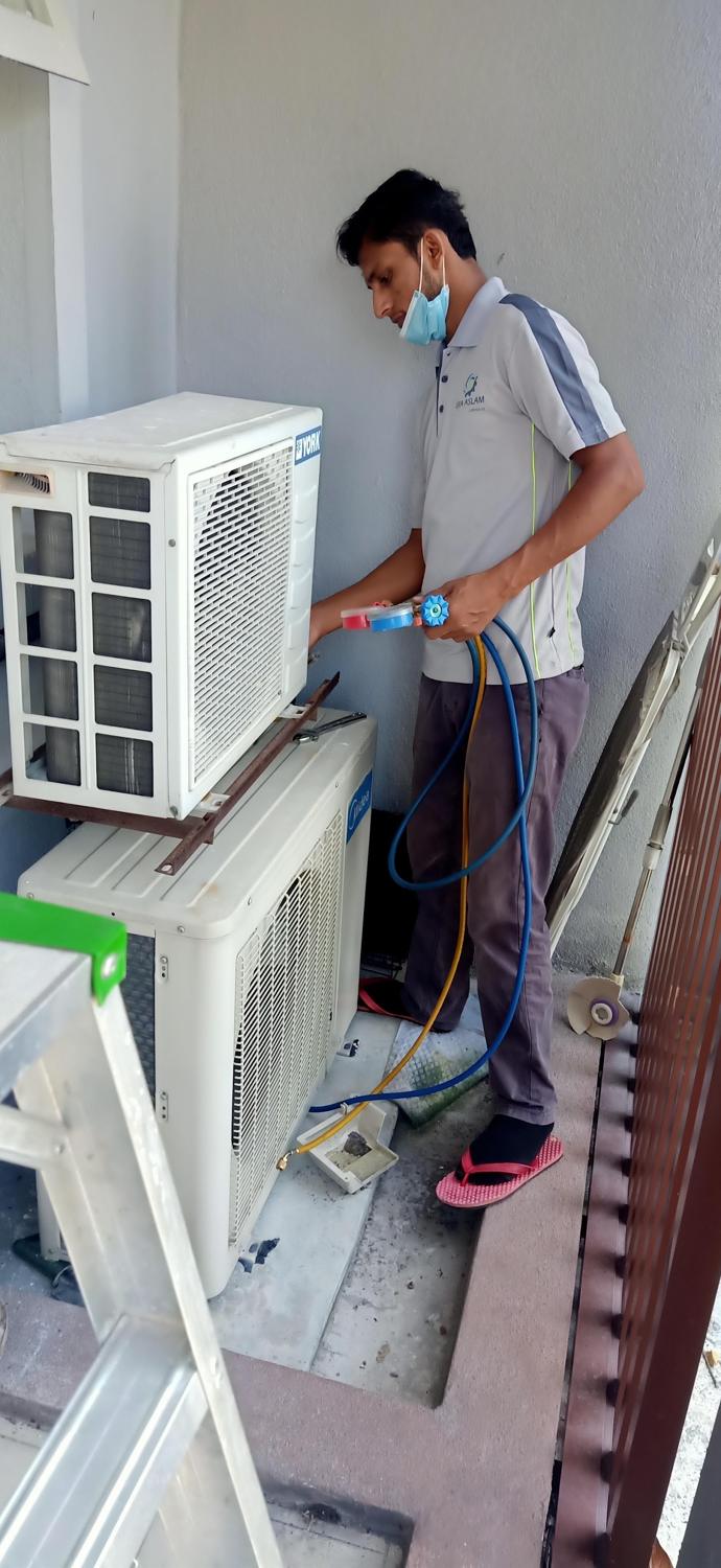 Technician refilling gas at an outdoor unit